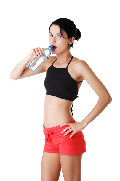 Athletic woman drinking water in sportswear - Photo, Image