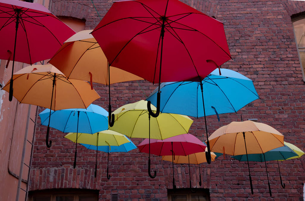 barevné deštníky na nádvoří cihlového domu, cihlová zeď - Fotografie, Obrázek