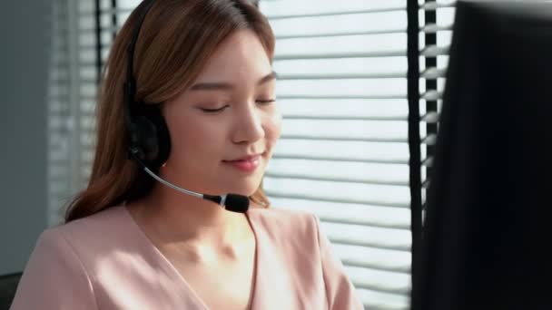 Competent female operator working on computer and while talking with clients. Concept relevant to both call centers and customer service offices. - Séquence, vidéo