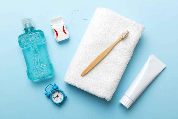 Mouthwash and other oral hygiene products on colored table top view with copy space. Flat lay. Dental hygiene. Oral care products and space for text on light background. concept. - Foto, Imagen