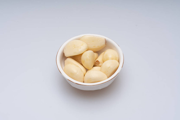 Mletý a loupaný česnek na bílém pozadí - Fotografie, Obrázek