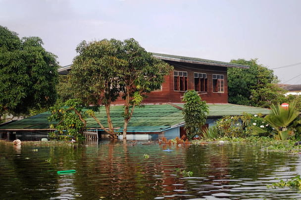 View landscape cityscape countryside of Bang Bua Thong city while water flood vintage wood home and inundation retro wooden house of thai people at country rural in Nonthaburi, Thailand - Photo, Image