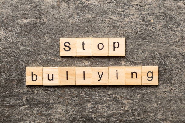 Dejar de intimidar palabra escrita en bloque de madera. Stop Bullying texto en la mesa de cemento para su diseño, concepto. - Foto, imagen