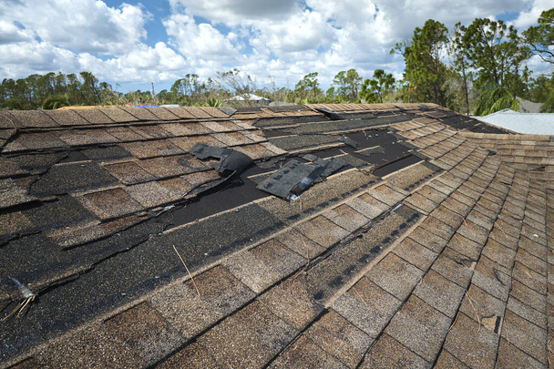 Beschädigtes Hausdach mit fehlenden Schindeln nach Hurrikan Ian in Florida. Folgen von Naturkatastrophen. - Foto, Bild