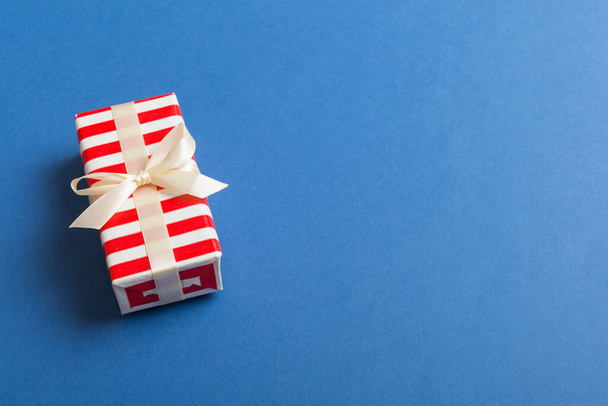 Envuelto navidad u otro día de fiesta hecho a mano presente en papel con cinta de colores. Caja de regalo, decoración de regalo en la mesa, vista superior con espacio para copiar. - Foto, imagen