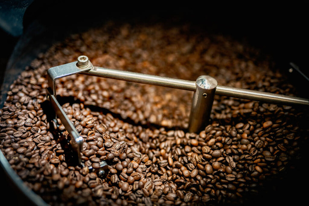 Close up spatola macchina con chicchi di caffè arabica marrone vicino a attrezzature speciali. Concetto di fabbrica. - Foto, immagini