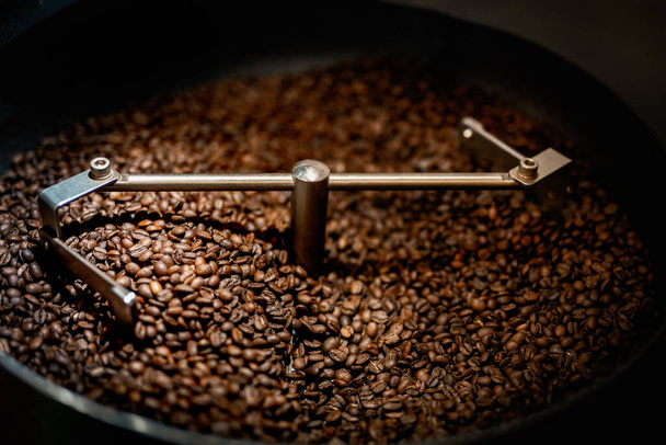 Close up machine spatula with brown arabica coffee beans near special equipment. Factory concept. - Φωτογραφία, εικόνα