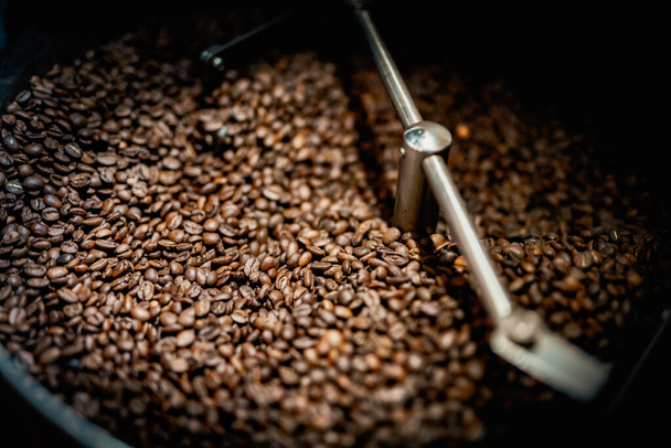 Zavřít stroj špachtle s hnědým arabica kávová zrna v blízkosti speciálního vybavení. Tovární koncept. - Fotografie, Obrázek