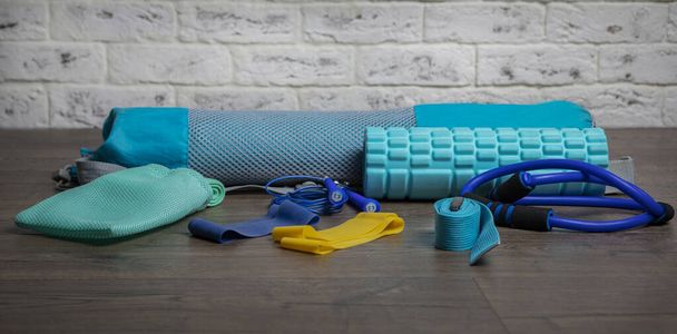 Front view on jump ropes, rubber fitness bands and blue fitness mat. Healthy lifestyle and copy space, place for text concept - Zdjęcie, obraz