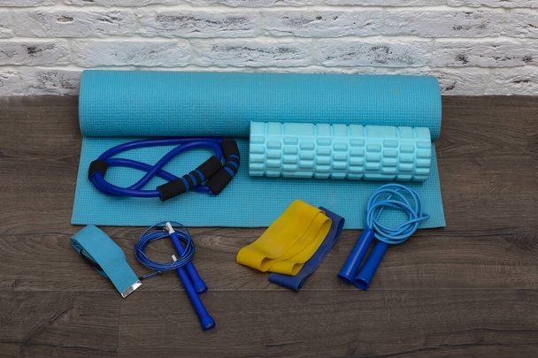 Vista frontal de las cuerdas de salto, bandas elásticas de fitness y alfombra de fitness azul. Estilo de vida saludable y espacio de copia, lugar para el concepto de texto - Foto, Imagen
