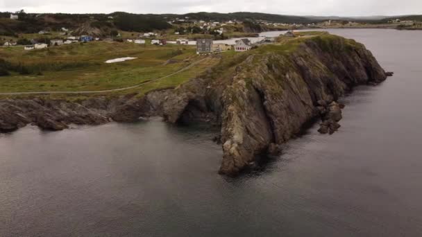 Trinity yakınlarındaki yüksek uçurumlara ve okyanus koylarına bakan renkli evleri olan havadan küçük Newfoundland topluluğu.. - Video, Çekim