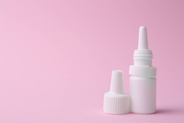 Bottle of medical drops on pink background. Space for text - Foto, afbeelding