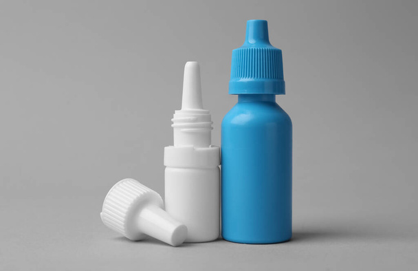 Bottles of medical drops on grey background - Foto, imagen