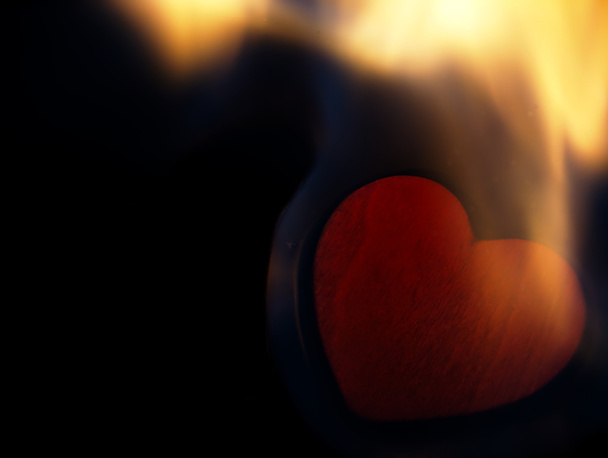Coração flamejante sobre um fundo preto
. - Foto, Imagem
