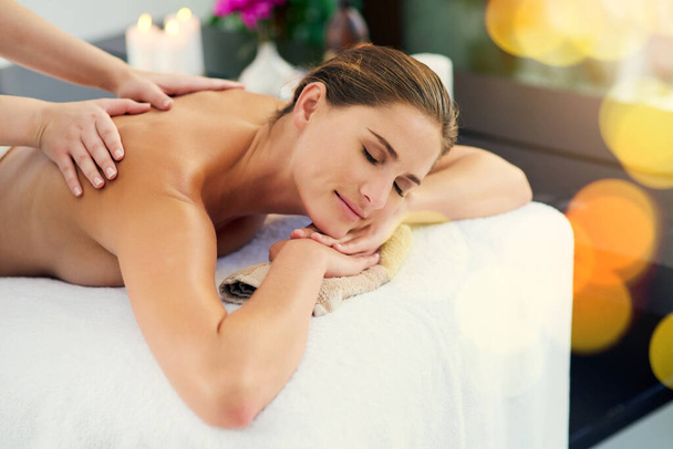 Kosketusterapian parantava voima. kaunis nuori nainen makaa hierontapöydällä päiväkylpylässä - Valokuva, kuva