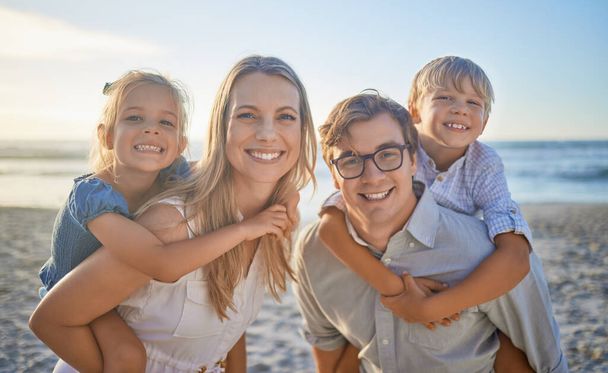 Πορτρέτο μιας ευτυχισμένης καυκάσιας οικογένειας που στέκεται μαζί στην παραλία. Αγαπημένοι γονείς περνούν χρόνο με τα δύο παιδιά τους κατά τη διάρκεια των οικογενειακών διακοπών στην παραλία. - Φωτογραφία, εικόνα