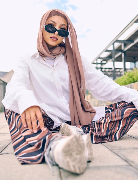 Beautiful young arab woman posing outdoors in a headscarf. Attractive female muslim wearing a hijab posing outside. Shes all about style and fashion. Mixed race woman looking confident and trendy. - Foto, Bild