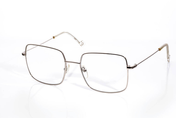 Brille mit Dioptrien in dünnem Goldrahmen auf weißem Hintergrund - Foto, Bild