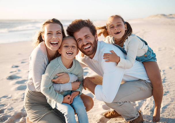 Cheerful family bonding on the beach. Portrait of a happy family on a beach vacation. Carefree family enjoying a holiday by the sea. Parents being affectionate with their daughters on holiday. - Zdjęcie, obraz