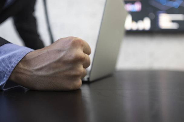 Close up of a fist hitting the desktop in a business concept - Photo, Image