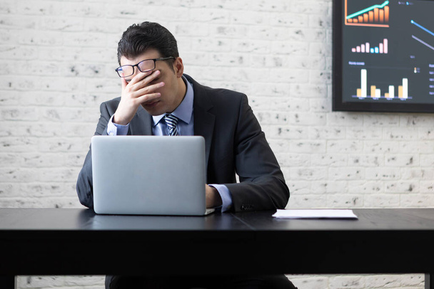 Unavený frustrovaný a přepracovaný podnikatel sedí v kanceláři a přemýšlí o problémech v podnikání - Fotografie, Obrázek