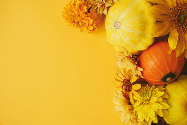 Happy Thanksgiving! Colorful autumn flowers, pumpkins, pattypan squashes flat lay on yellow background. Seasons greeting card template with space for text. Hello Fall. Autumn banner - Photo, image