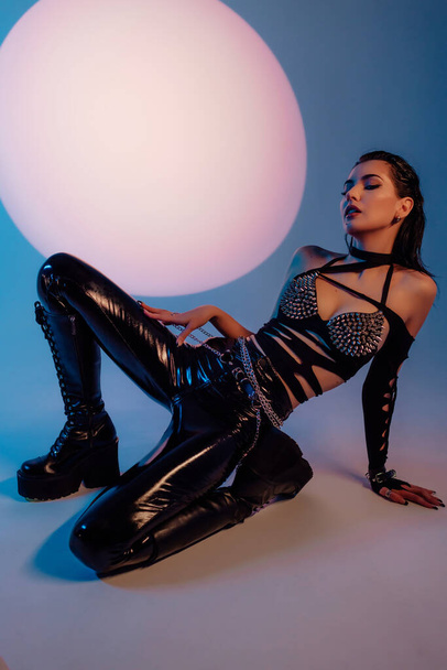 Hot sexual woman in latex suit on a dark background. Woman dominance concept. Beautiful fashion girl with perfect body. - Zdjęcie, obraz