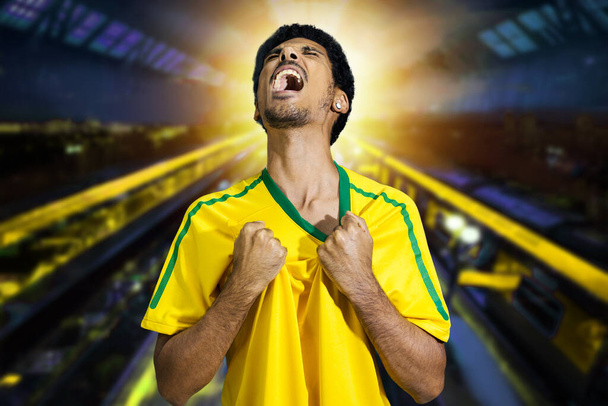Афро-бразилец в желтой футболке на Кубке 2022, болея за Бразилию, чтобы стать чемпионом. - Фото, изображение