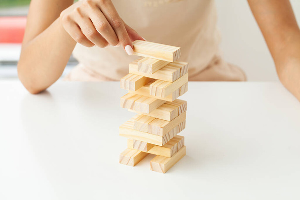 Рука молодої ділової жінки грати в дерев'яні блоки з стратегією та систематичним управлінням проектами
. - Фото, зображення