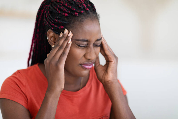 Primer plano Shot Of Sick Black Young Woman Sufriendo de dolor de cabeza en casa, Millennial Afro-Americana Femenina Con Trenzas Peinado Sensación de Malestar, Tocando Templos Y Frunciendo el ceño, Copiar el Espacio - Foto, Imagen
