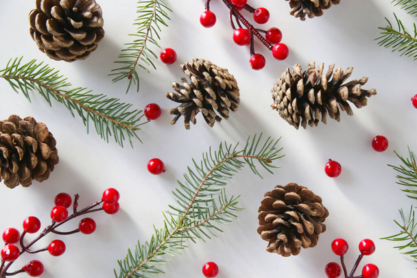branches d'arbre de Noël, cônes de conifères et baies rouges, biscuits de vacances et ornements, vue sur le dessus sur fond blanc. Noël, vacances d'hiver, concept de nouvelle année. - Photo, image