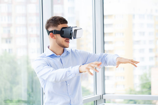 Молодий чоловік використовує гарнітуру віртуальної реальності на технологічній виставці
. - Фото, зображення
