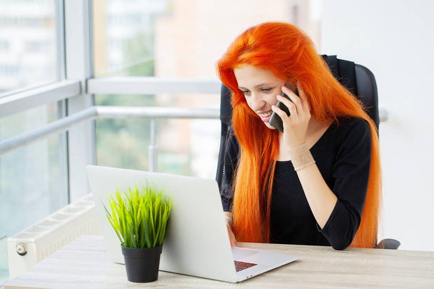 Cheerful red haired female economist develops financial startup project. - Фото, зображення