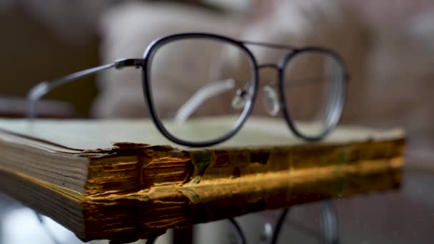 Gros plan de lunettes ou de lunettes sur un vieux livre au bureau 4k - Séquence, vidéo