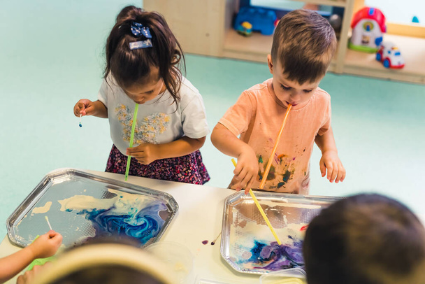 niños utilizando técnicas modernas de pintura en el jardín de infantes, concepto de niños de tiro medio. Foto de alta calidad - Foto, Imagen
