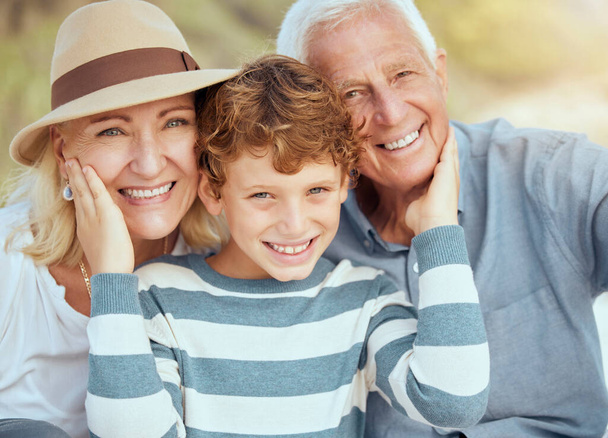 Happy caucasian grandparents sitting with grandson on a beach. Adorable, happy, child bonding with grandmother and grandfather in a garden or park outside. Boy with foster parents. - Foto, afbeelding