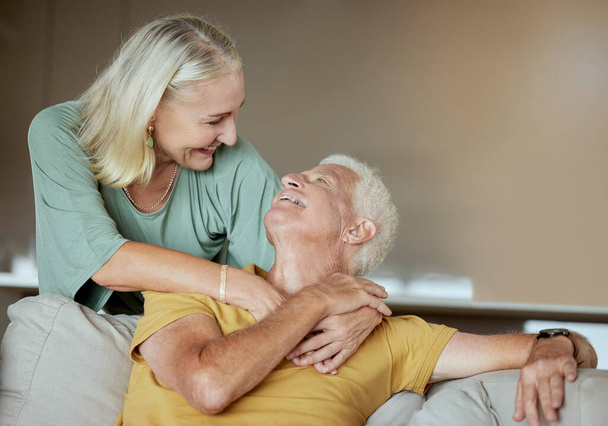 Happy elderly couple bonding and enjoying retirement together. Senior caucasian man and woman being affectionate on a sofa at home. - Photo, Image