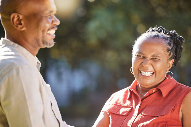 Feliz pareja afectuosa afroamericana madura compartiendo un momento íntimo afuera en el parque durante el verano. Enamorados ancianos sonriendo y abrazando mientras pasan tiempo de calidad juntos al aire libre. - Foto, imagen