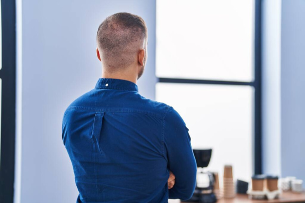 Молодий іспаномовний чоловік бізнесмен стоїть на задньому плані в офісі
 - Фото, зображення
