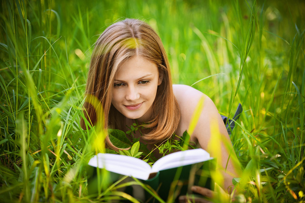 Portrait of young woman reading a book - Fotó, kép