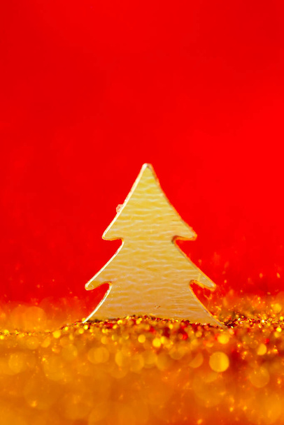 Papel de parede de Natal em ouro e em uma cor vermelha.Árvore de Natal mini em brilho de ouro em um fundo vermelho.Fundo festivo. - Foto, Imagem