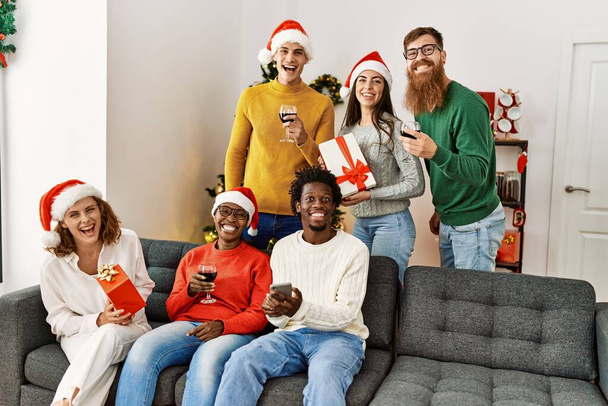 Group of young people on christmas celebration sitting on the sofa at home. - Fotografie, Obrázek