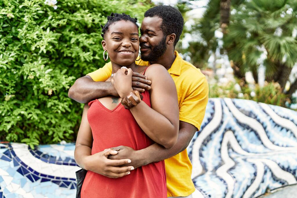 Genç Afro-Amerikan çifti mutlu bir şekilde gülümsüyor ve şehre sarılıyorlar.. - Fotoğraf, Görsel