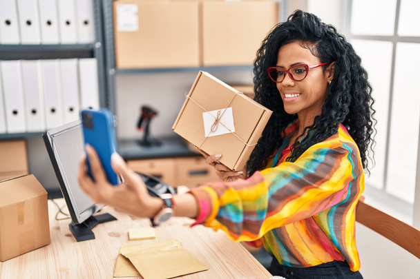 Afrikai amerikai nő üzleti dolgozó gazdaság csomag szelfi az okostelefon az irodában - Fotó, kép