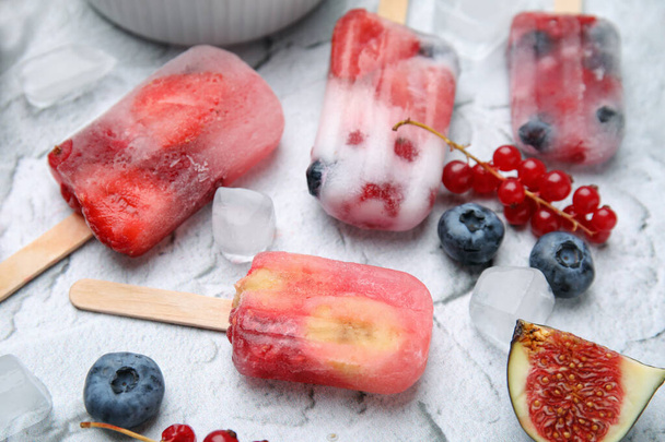 Tasty fruit and berry ice pops on light table, closeup - 写真・画像