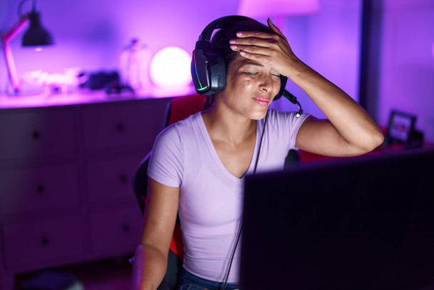 Young beautiful hispanic woman streamer stressed using computer at gaming room - Fotoğraf, Görsel