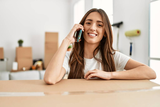 Young hispanic woman smiling confident talking on the smartphone at new home - Fotoğraf, Görsel