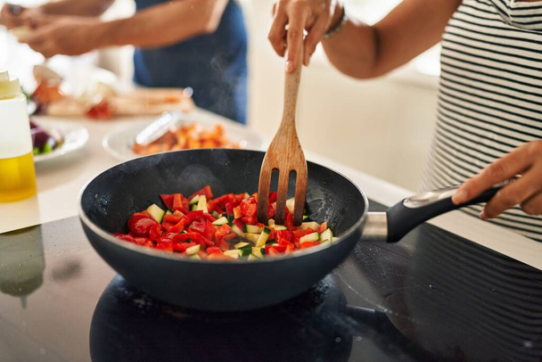 Middle age hispanic couple cooking food on frying pan at kitchen - Photo, Image