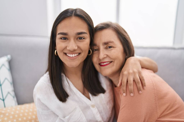 Two women mother and daughter sitting on sofa together at home - Foto, Imagen