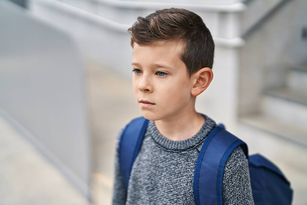 Blond child student standing with serious expression at school - Photo, image
